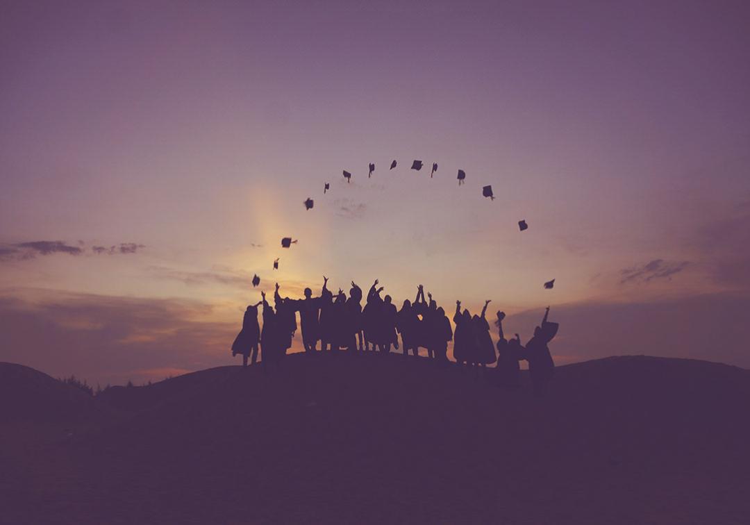 A group of graduating students throwing their academic caps into the air. 
