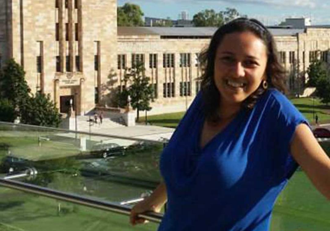Adrianova Carrion Falla smiling at the camera with the UQ Forgan Smith building in the background