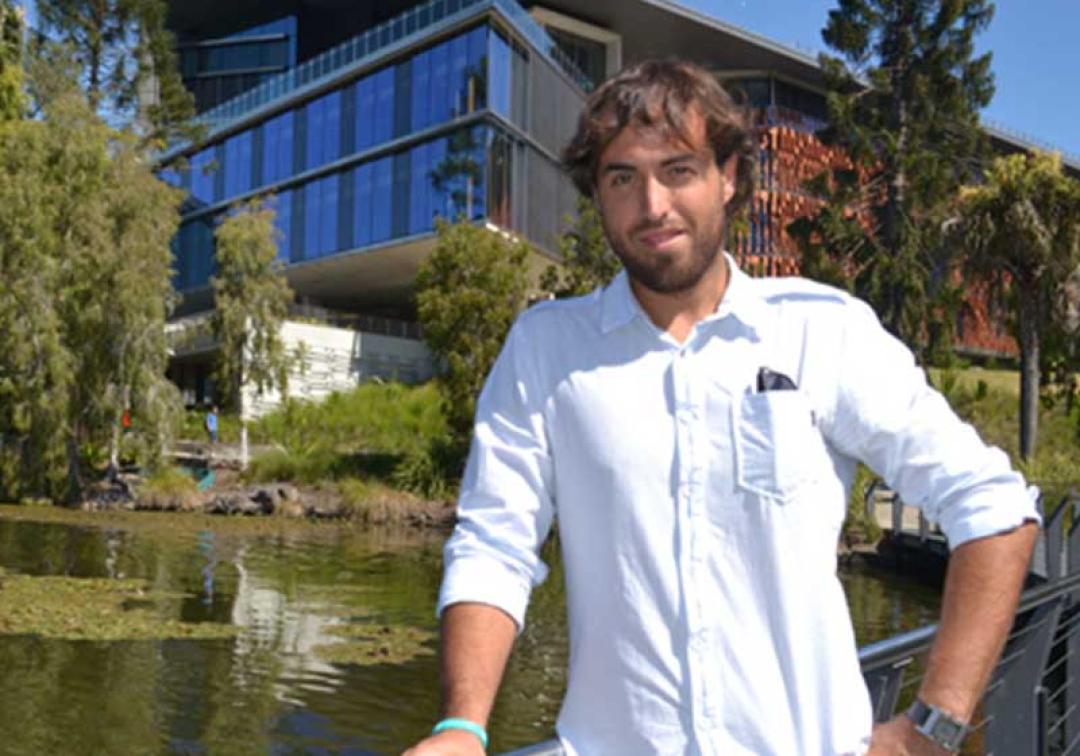 Diego Montiel standing in front of the UQ lakes and Advanced Engineering Building.
