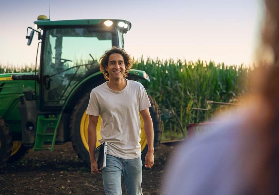 Ag student standing in a field with a tractor