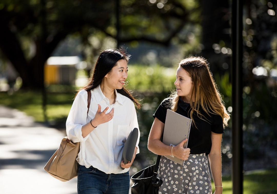 Two female students walking and talking