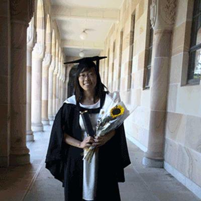 Renee Nicole Yn Wen Ng in graduation cap and robes, smiling and holding a sunflower