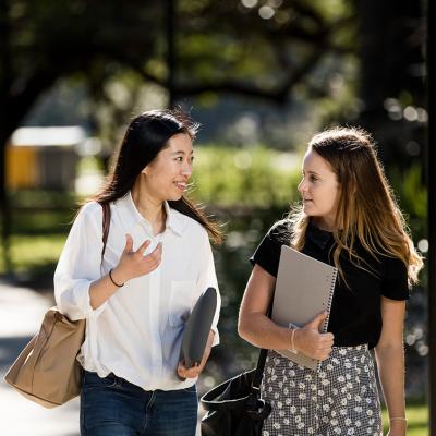 Two female students walking and talking