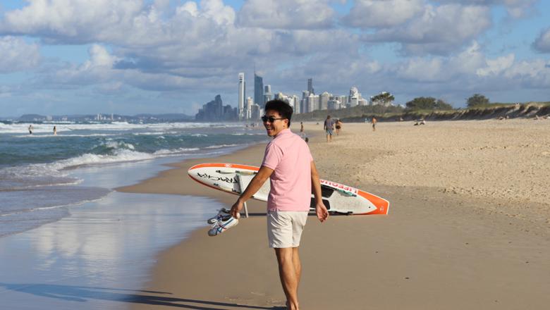 International student on beach with Gold Coast skyline in background