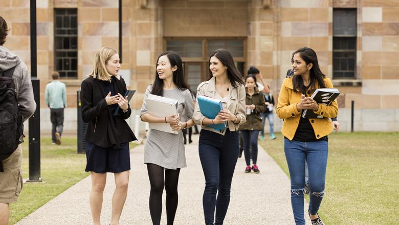 An Academic and students walking together in the Great Court.
