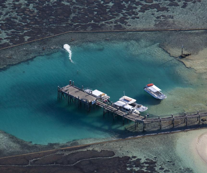 Aerial view of boats moored at a jetty on the reef at Heron Island Research Station