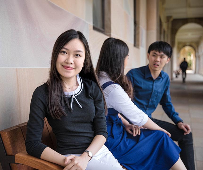 Student looking at camera with two others beside her